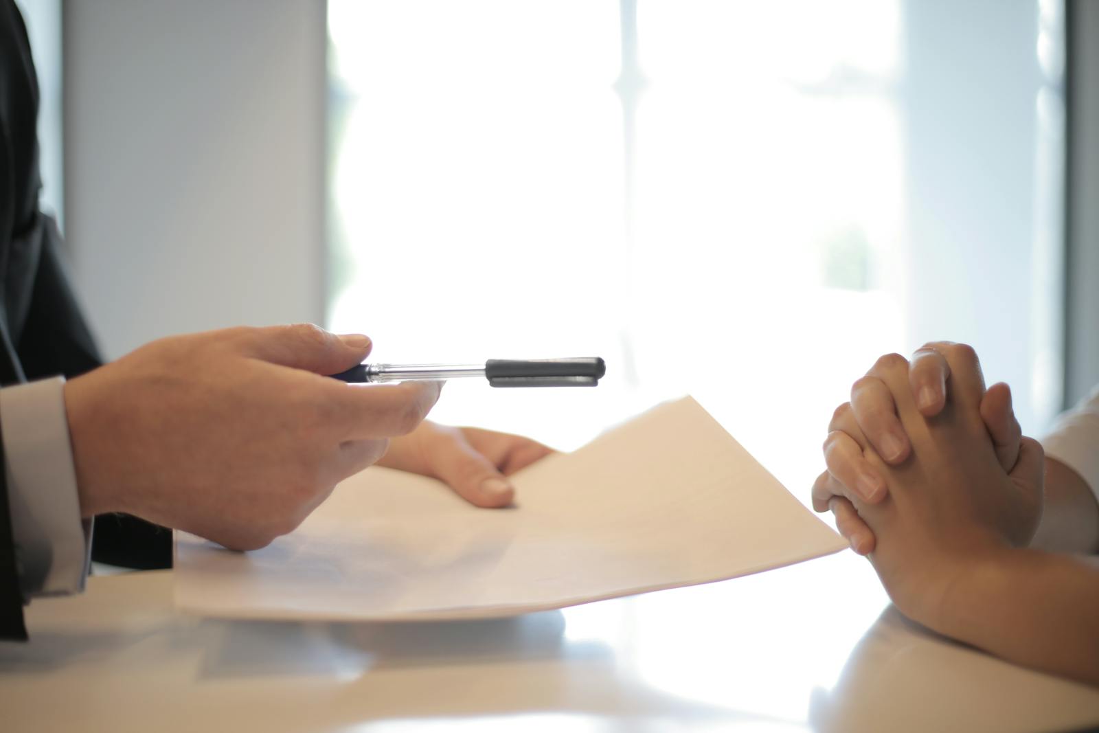 Hand reviewing a printed contract with marks and highlights