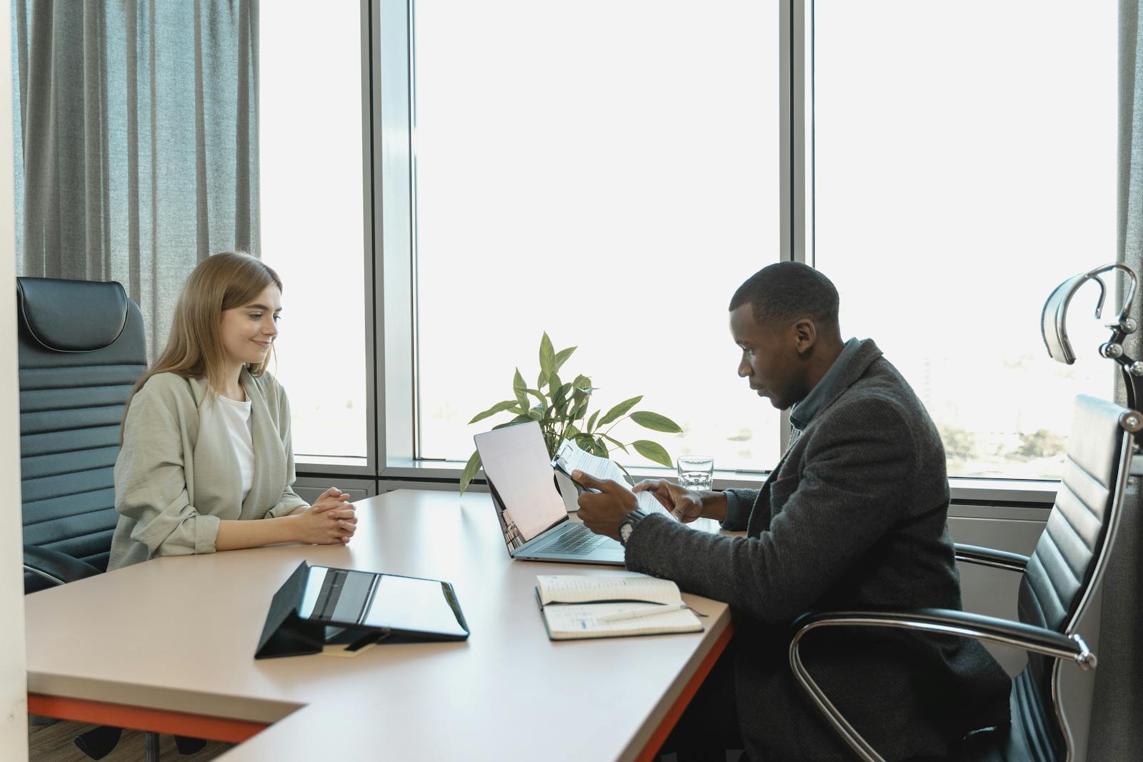 Person reading a paper contract document with laptop