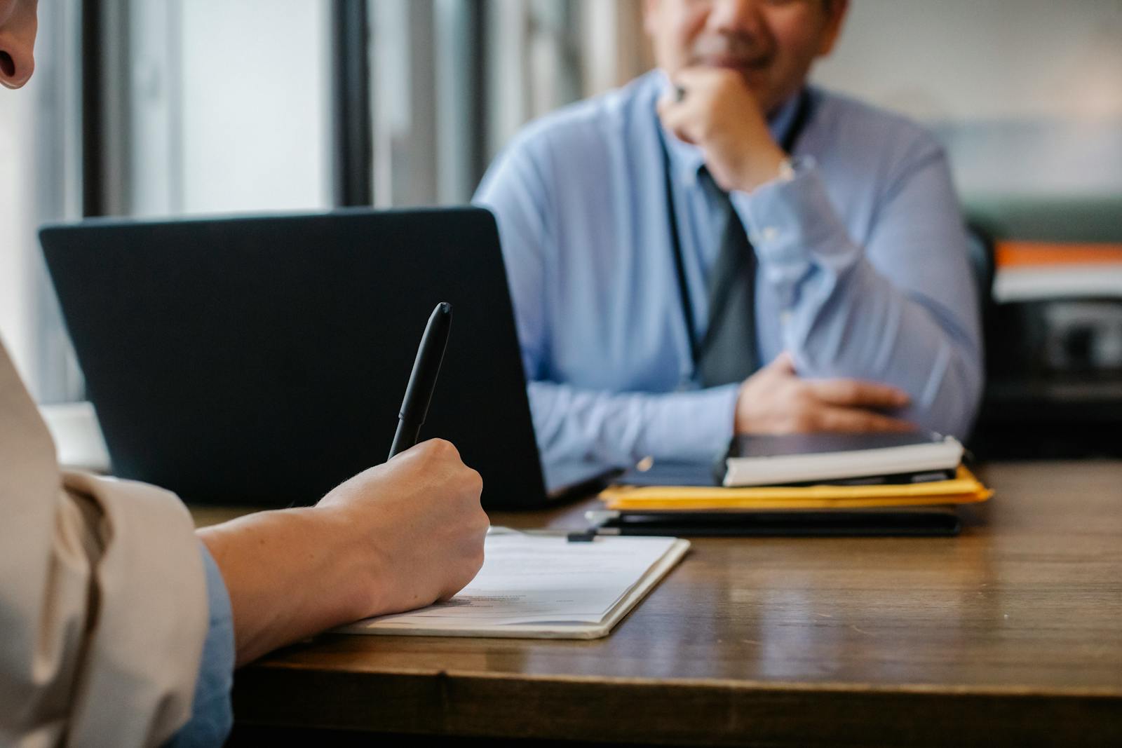 Two people negotiating contract terms across a table